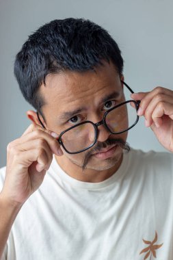 Sanatçı bıyıklı yüz adam beyaz arka planda kızgın hareket gözlüğü takıyor