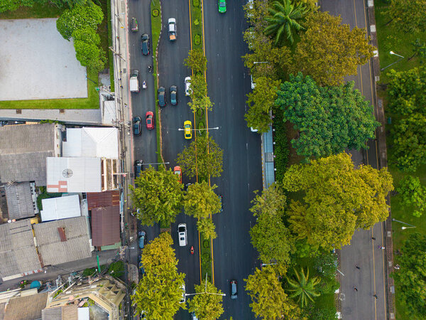 Aerial view car trabsport rushing hour on city road with green tree park Bangkok Thailand