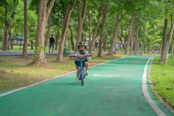 都会の公園で自転車に乗ることを楽しむ小さなアジアの赤ちゃん屋外運動 — ストック写真