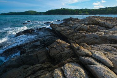 Tropikal deniz sahili mavi gökyüzünü kabarık bulutlu doğa manzarasıyla dalgalandırıyor.