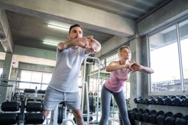 Spor salonunda çalışan akıllı erkek ve kadın sporcu sağlıklı bir yaşam tarzı.