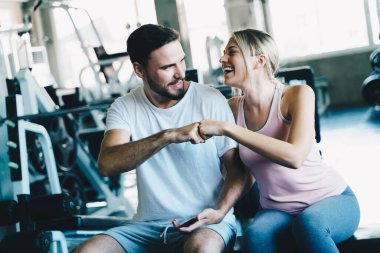 Spor salonunda çalışan akıllı erkek ve kadın sporcu sağlıklı bir yaşam tarzı.