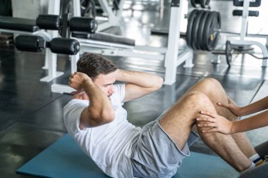 Spor adamı, kadın eli için spor salonunda yoga minderi egzersizi yapıyor.