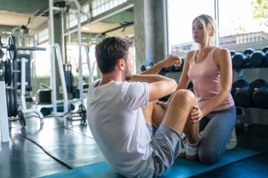 Spor adamı, kadın eli için spor salonunda yoga minderi egzersizi yapıyor.