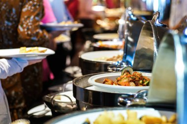 İnsanlar otel restoranında açık büfe yemek ve salata yer. Seminer, yemek ve içecek endüstrisi.