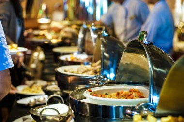İnsanlar otel restoranında açık büfe yemek ve salata yer. Seminer, yemek ve içecek endüstrisi.