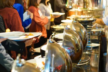 İnsanlar otel restoranında açık büfe yemek ve salata yer. Seminer, yemek ve içecek endüstrisi.