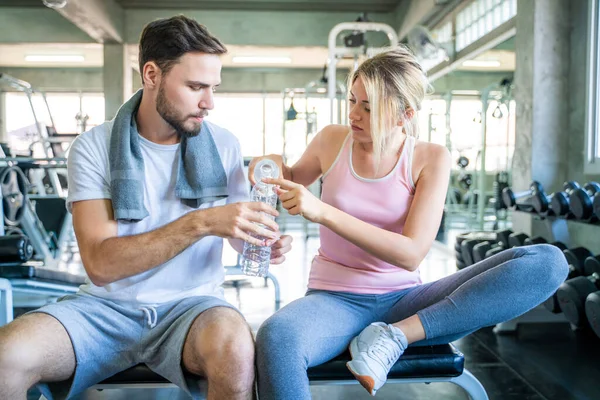 stock image Happy couple drinkking water after exercise in sport fitness gym happy relationship