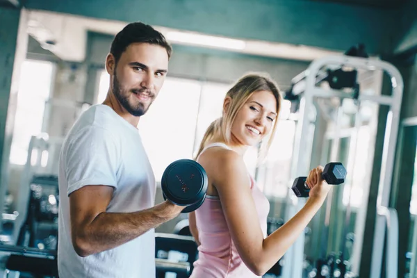 stock image Man and woman working out with dumbbell in fitnes sport gym healthy trainning with boyfriend