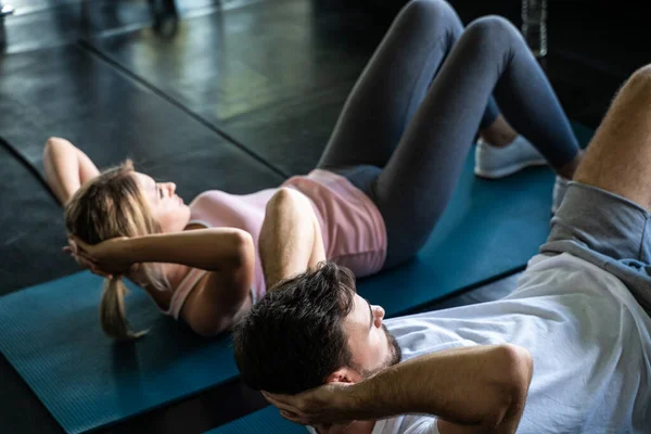 stock image Man and woman sit up on mat in sport gym working out healthy lifestyle