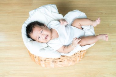 Yeni doğmuş erkek bebek, tahta sepetin üzerinde uzanmış Asyalı çocuk.