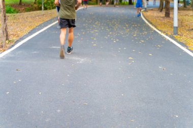 Açık yeşil ağaç parkında koşan bulanık insanlar.