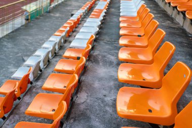 Açık hava spor arka planında turuncu beyaz stadyum sandalyeleri