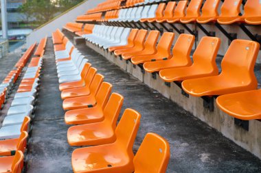 Açık hava spor arka planında turuncu beyaz stadyum sandalyeleri