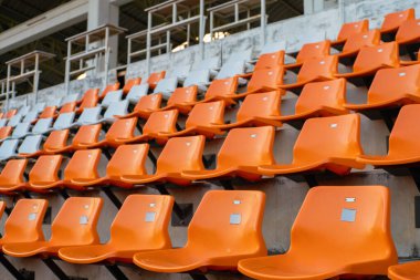 Açık hava spor arka planında turuncu beyaz stadyum sandalyeleri