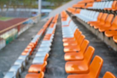Açık hava spor arka planında turuncu beyaz stadyum sandalyeleri