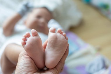 Bebek bakımı konseptine uzanmış bebek ayaklı anne eli.