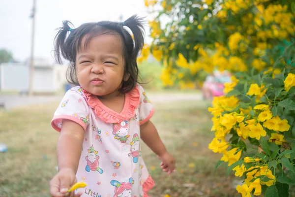 Güzel Asyalı Küçük Kız Dışarıda Sarı Çiçeklerle Oynuyor Parkın Işıklarıyla — Stok fotoğraf