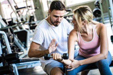 Sport man trainning woman exercise lifting weight in sport gym fitness gym