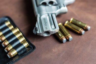 .44 magnum revolver gun with bullet on leather background personal defence