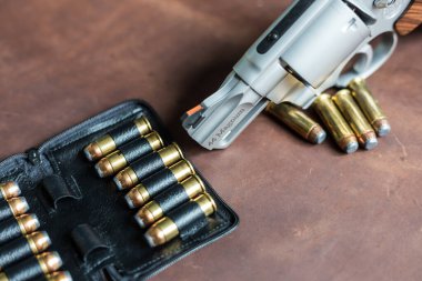 .44 magnum revolver gun with bullet on leather background personal defence