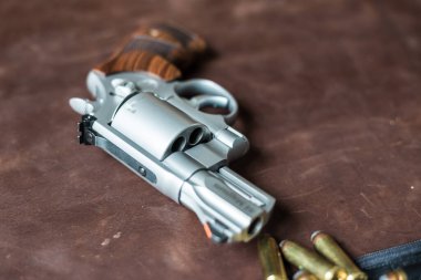 .44 magnum revolver gun with bullet on leather background personal defence