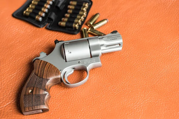 .44 magnum revolver gun with bullet on leather background personal defence