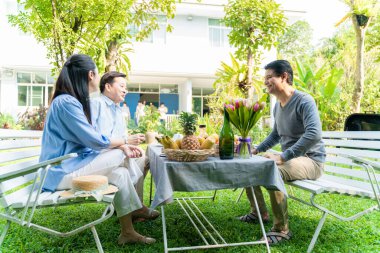 İş adamı ve kadın sabah kahvaltısı ile ev bahçesinde konuşuyorlar.