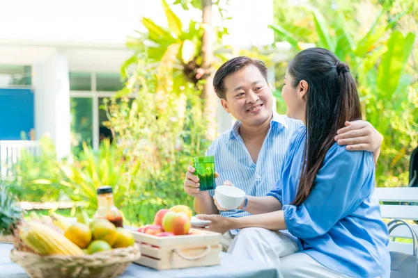 Business man and woman morning talk in home garden with breakfast food senior life