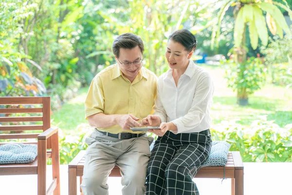 夫婦アジアのシニア使用タブレット一緒に庭の家で — ストック写真
