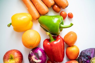 Renkli sağlıklı sebzeler ve beyaz arka planda meyveli yiyecekler. Sağlıklı vejetaryen yemekleri