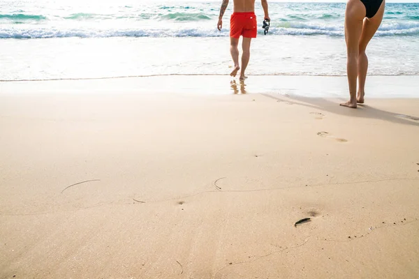 Couple walking on sea beach into the sea summer beach