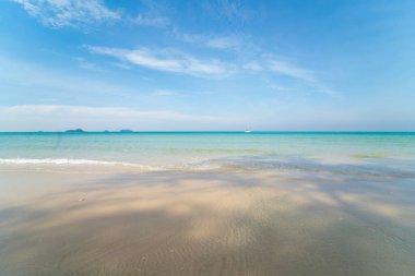 Beyaz kumlu deniz plajı dalgaları mavi gökyüzü bulutlu yaz tatili arka planı