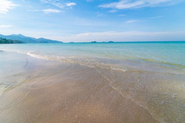 Beyaz kumlu deniz plajı dalgaları mavi gökyüzü bulutlu yaz tatili arka planı
