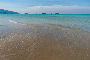 Beyaz kumlu deniz plajı dalgaları mavi gökyüzü bulutlu yaz tatili arka planı