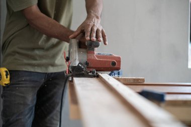 Marangoz yeni modern evde meşe ağacı ahşap kapı tesisatı ile çalışıyor.