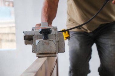 Çilingir marangoz yeni ev içi endüstrisinde ahşap kapıyla çalışıyor.