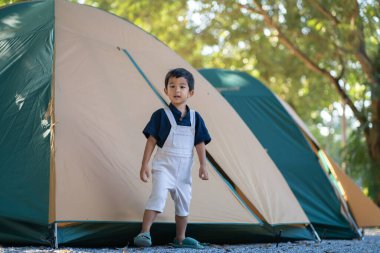 Mutlu anaokulu Asyalı çocuk kamp alanında kamp yapıyor doğa tatilinde.