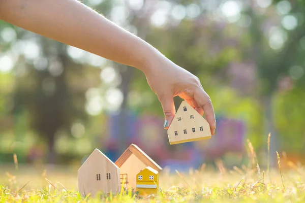 Wooden house model on green grass natire light resident real estate business concept