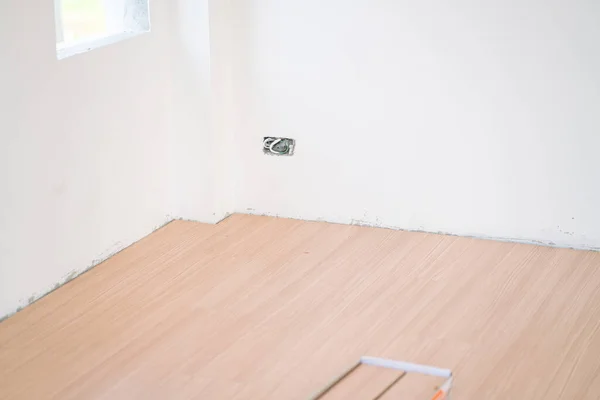 Light brown laminate floor in new modern room house interior building industry