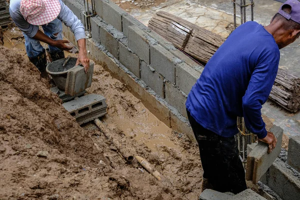 金属世論調査の建設現場でレンガの壁の建物に取り組んで機械的な男 — ストック写真