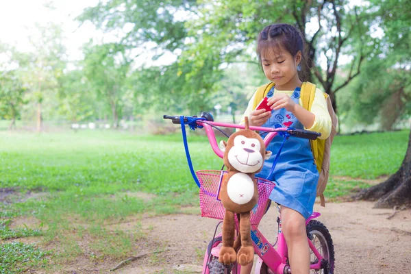 Ασιατική Κορίτσι Σχολείο Απολαμβάνοντας Ποδήλατο Υπαίθριο Πάρκο Πράσινο Δέντρο Φόντο — Φωτογραφία Αρχείου