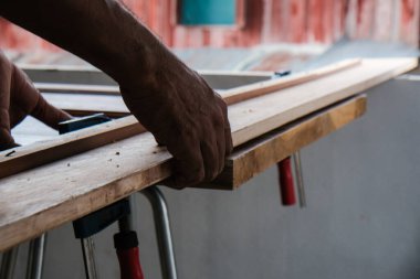 Marangoz, yeni bina iç binasının ahşap kapısı üzerinde çalışıyor.