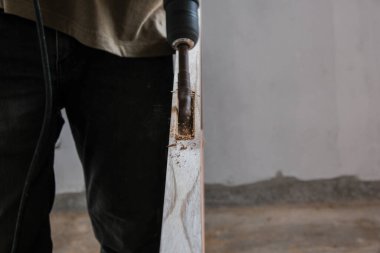 Marangoz, yeni bina iç binasının ahşap kapısı üzerinde çalışıyor.