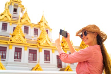 Sırt çantalı turist kadın, Bangkok Tayland 'da Buda Tapınağı' nı gezerken Samrtphone ile fotoğraf çekiyor.