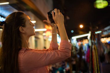 Gezgin sırt çantalı kadın gece Yaowarat caddesinde fotoğraf çekti. Bangkok Tayland 'ın geleneksel Asya şehrinde.