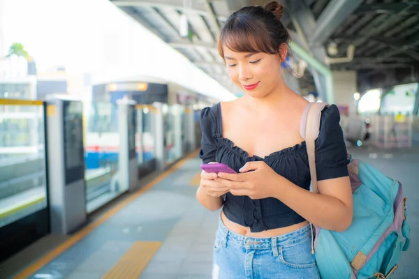 Piękna Azjatycka Kobieta Używać Smartfona Podróży Pociągu Miejskim Plecakiem — Zdjęcie stockowe