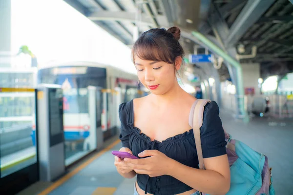 Piękna Azjatycka Kobieta Używać Smartfona Podróży Pociągu Miejskim Plecakiem — Zdjęcie stockowe