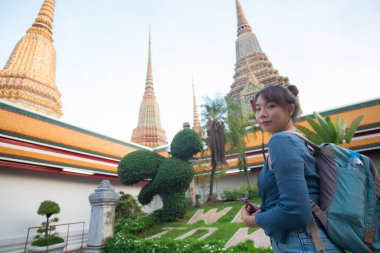 Turist Asyalı sırt çantalı kadın Bangkok Tayland 'da Budist tapınağını geziyor.