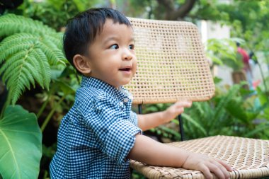 Küçük Asyalı çocuk bahçede oynuyor. Kahve parkında. Doğada mutlu zaman çocuğu.